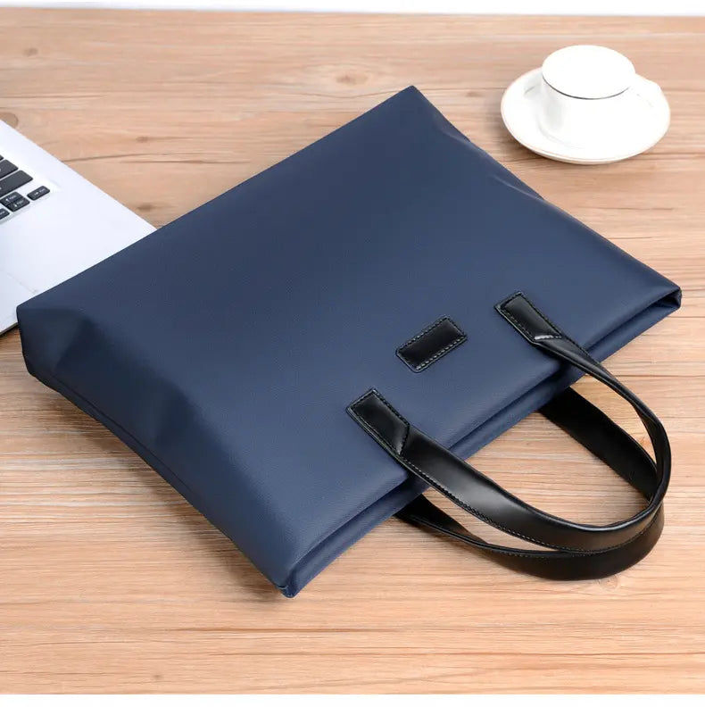 Navy blue briefcase on wooden desk with laptop and coffee cup