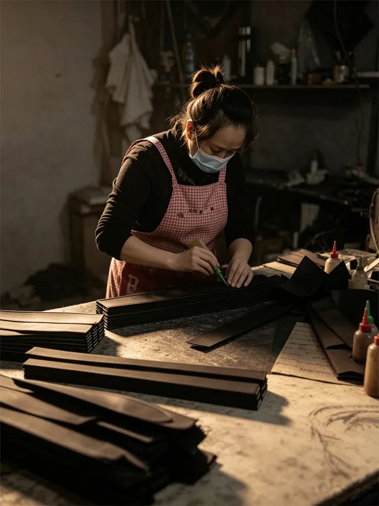 Close-up of a Range worker handcrafting leather bag parts, showcasing meticulous craftsmanship at Range